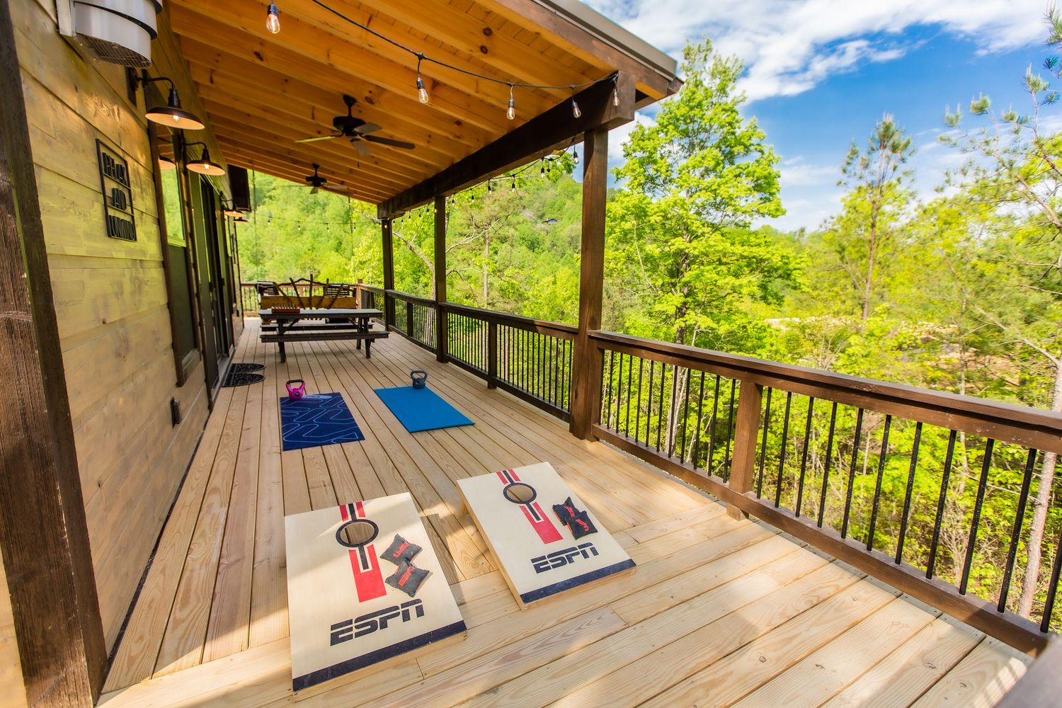 Spacious wooden deck with rocking chairs overlooking mountain views.