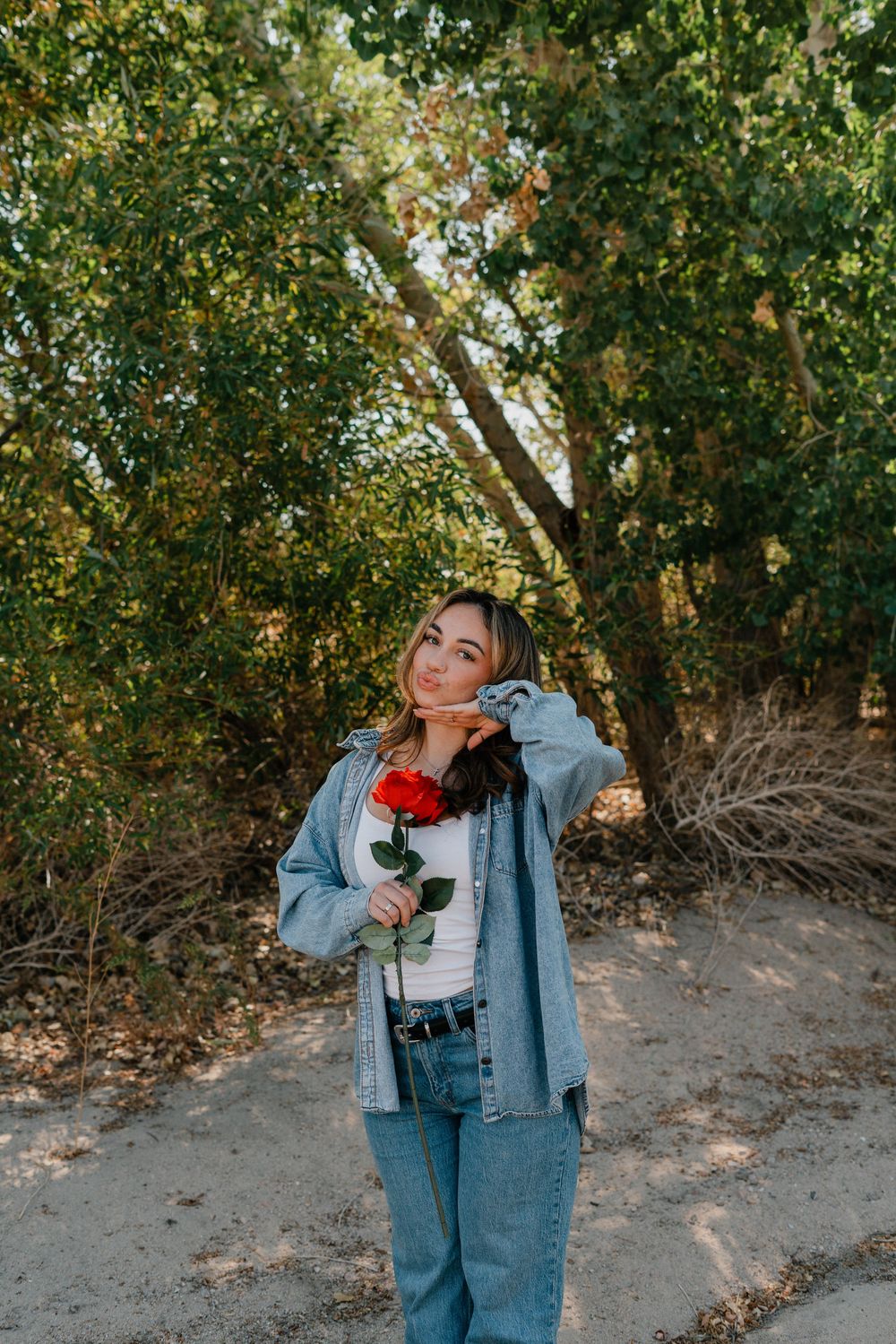 girl holding a rose in the woods