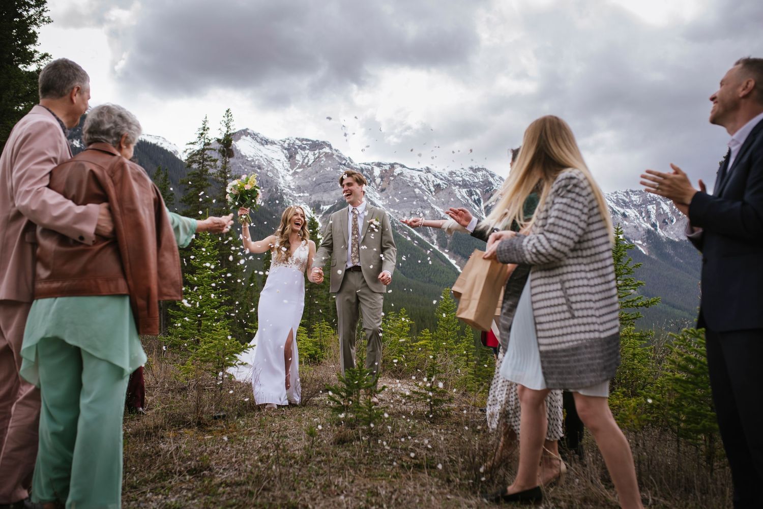 A scenic mountain wedding photo with fall foliage, a river, and peaks in the background.