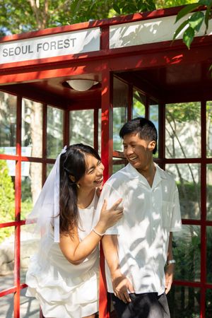 Couple sharing moments in a red-framed structure labeled Seoul Forest.