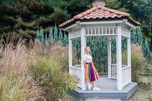 White gazebo surrounded by ornamental grasses and garden landscaping.