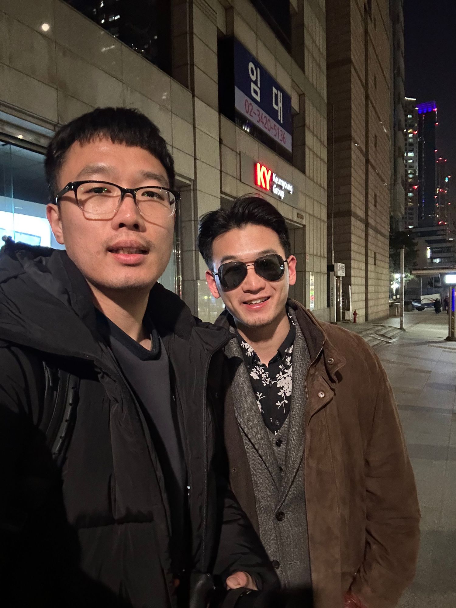 A series of five photos showing two friends standing together at night in an urban setting with city buildings behind them.