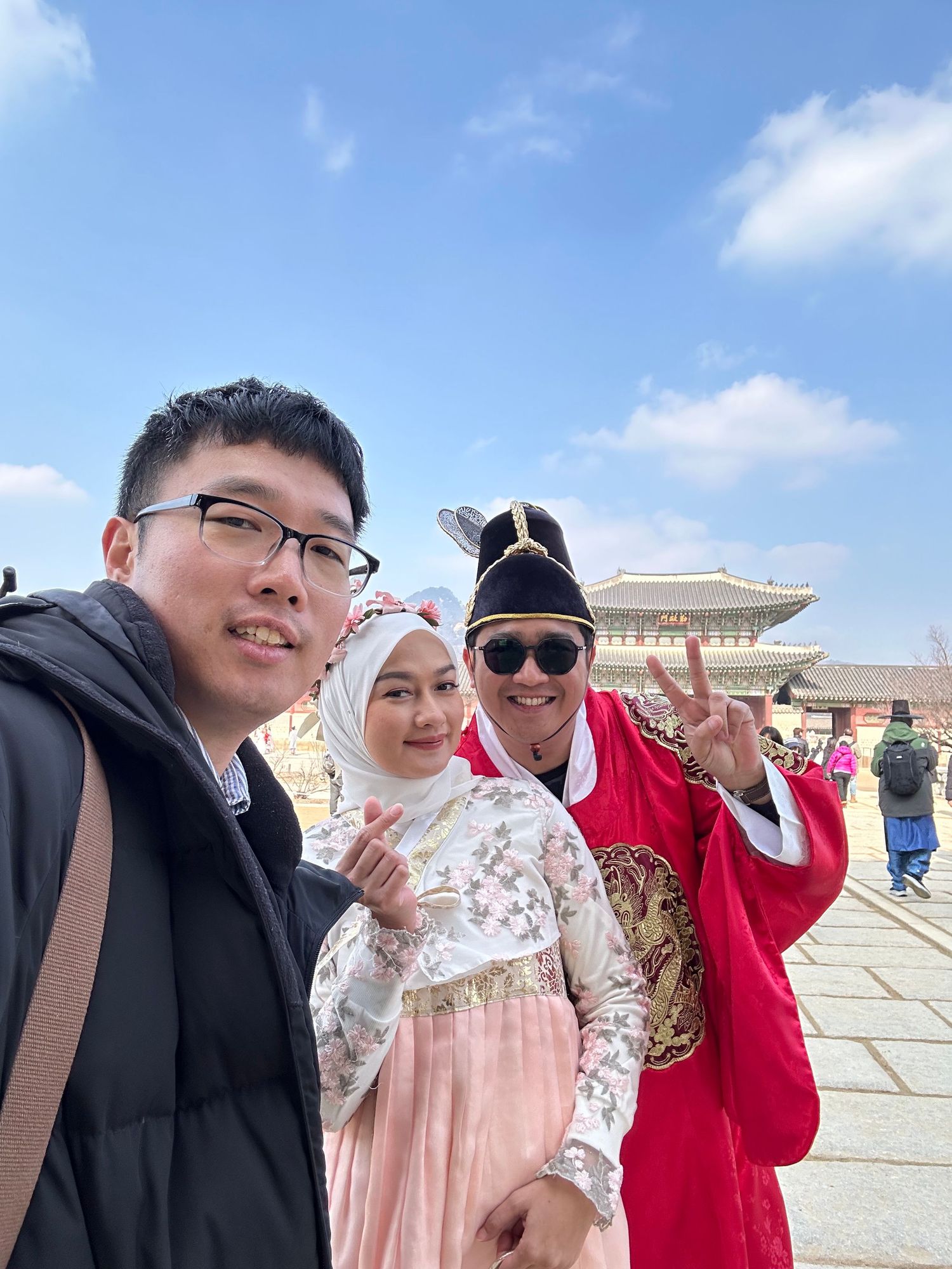 A group poses together at Tiananmen Square in Beijing on a sunny day, with the historic architecture visible behind them.
