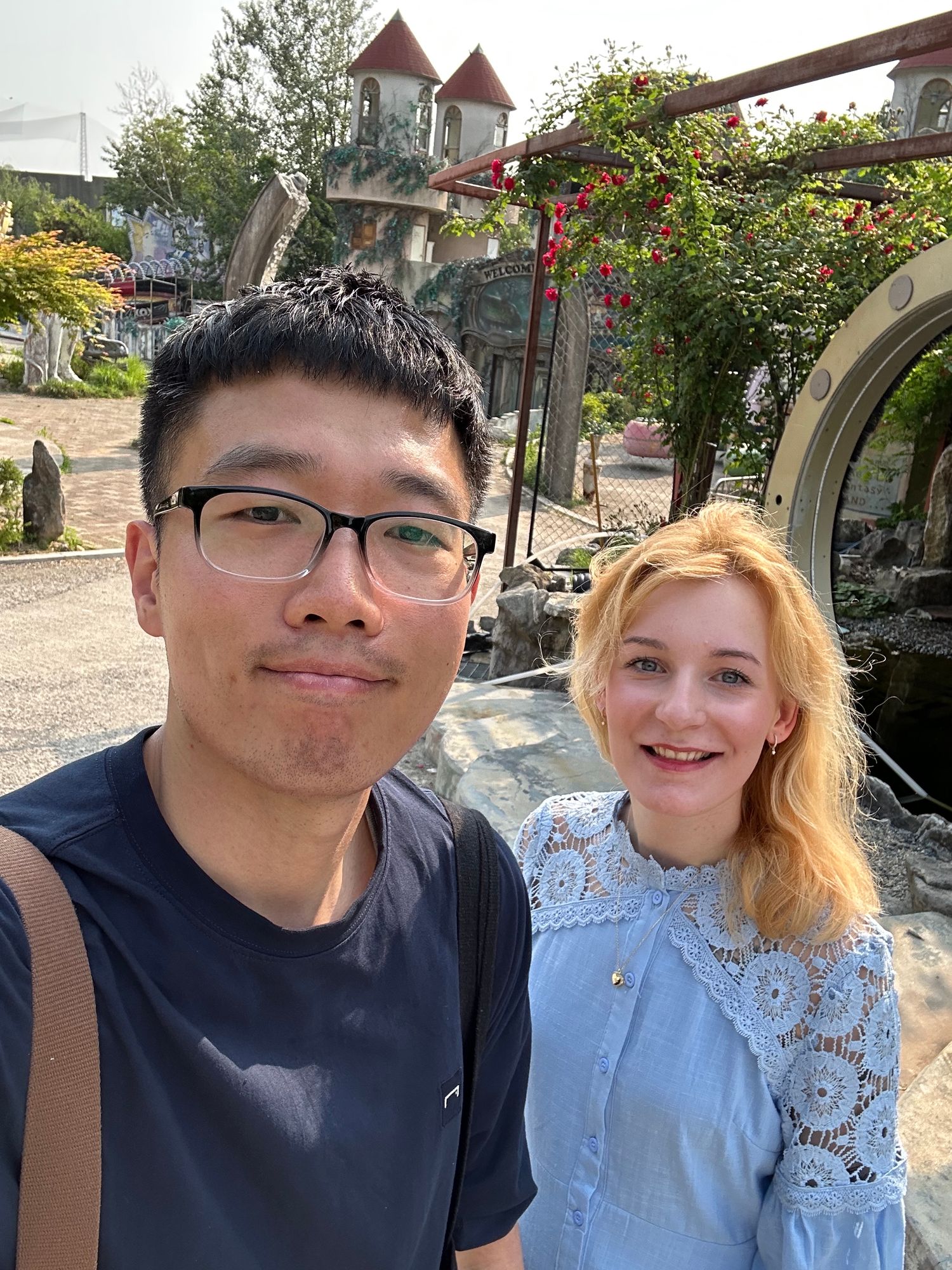 People taking outdoor selfies in front of natural scenery and buildings.