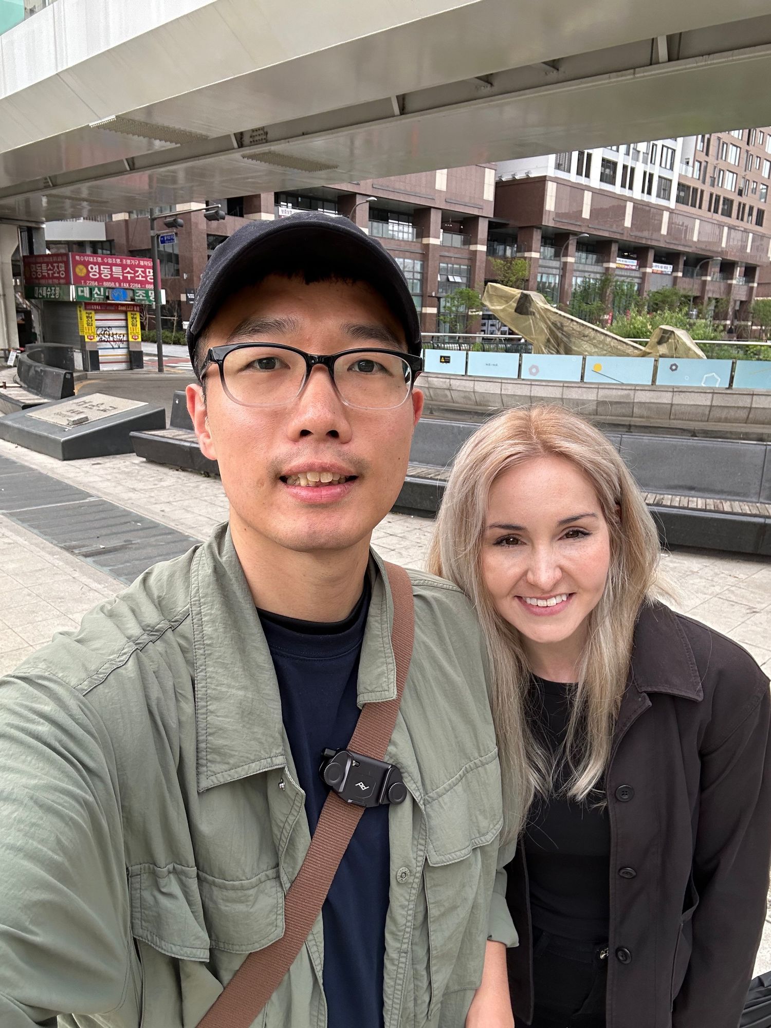 Two people posing for a series of outdoor selfie photos near city buildings and railings.