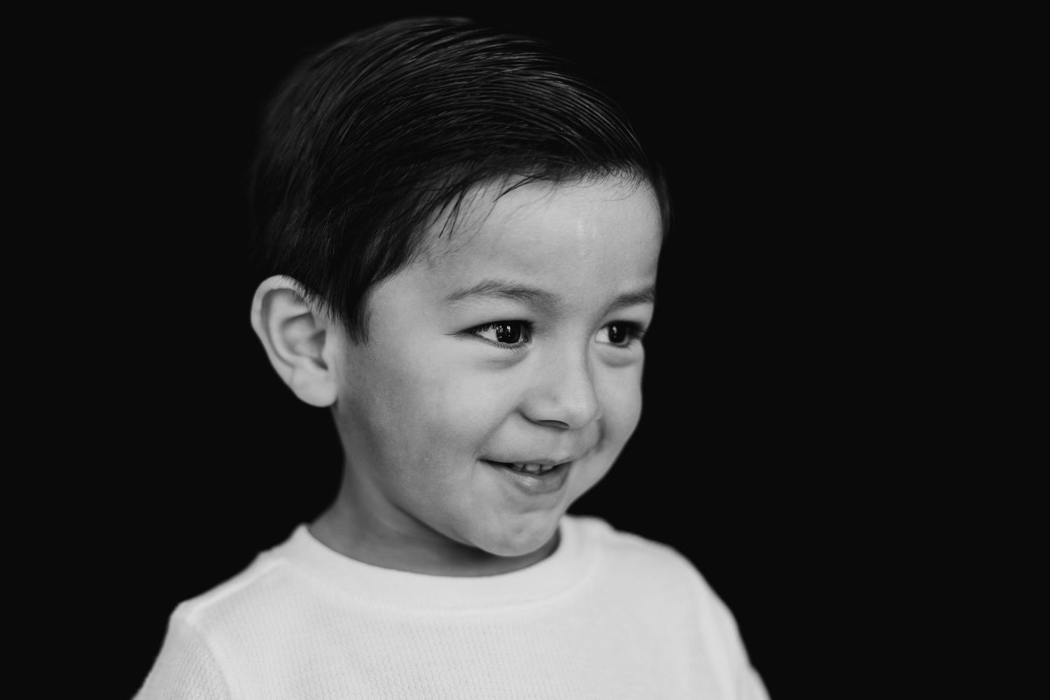 A series of black and white portraits showing various expressions and angles of a small child.