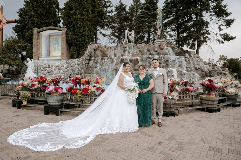 Wedding scenes at a stone venue with dramatic white dress train and decorative red floral arrangements.