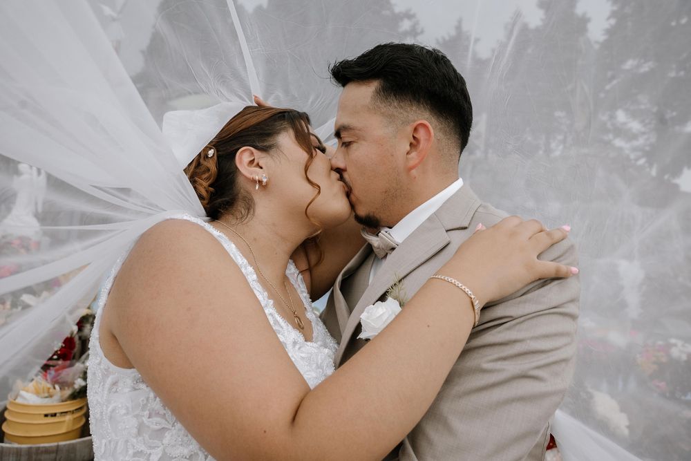 A romantic moment captured with a flowing white veil against a light background.