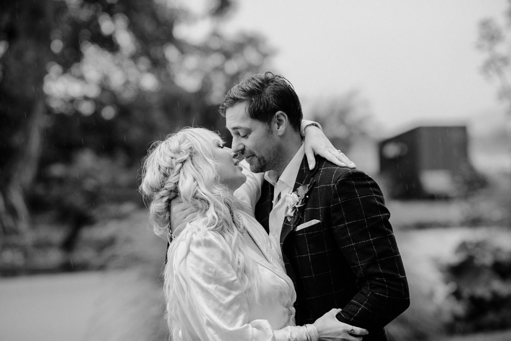 Black and white wedding image of a romantic moment between a couple during their Parehua elopement by August and Vine