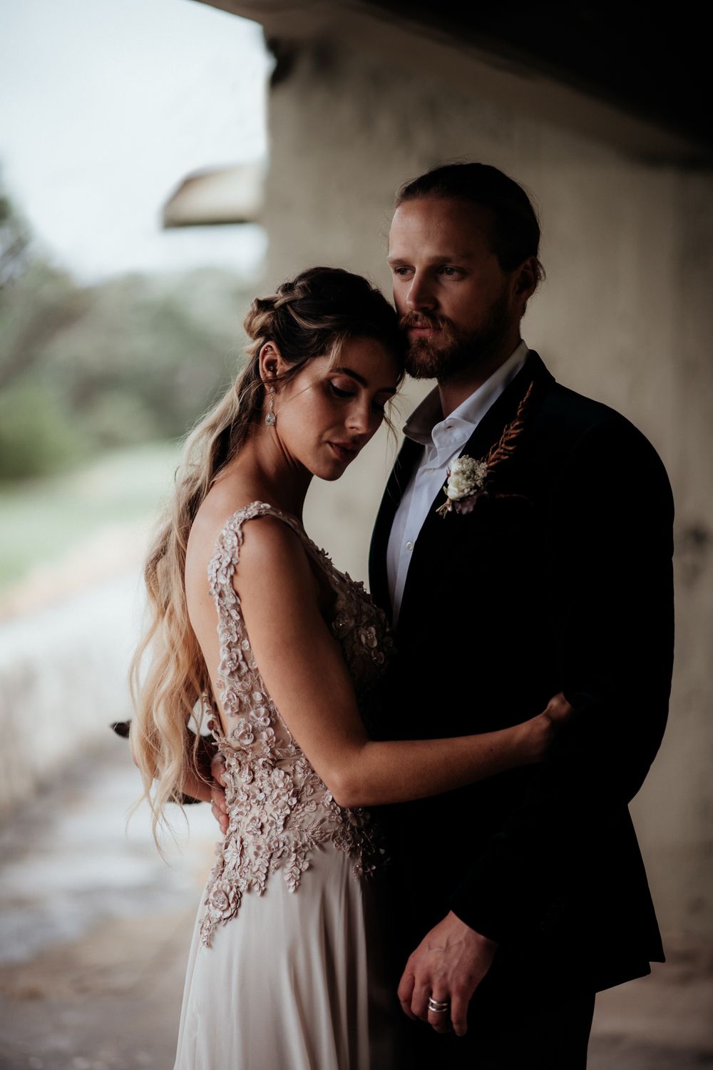 A bride and groom share an intimate moment in a moody setting creating a romantic atmosphere by August & Vine
