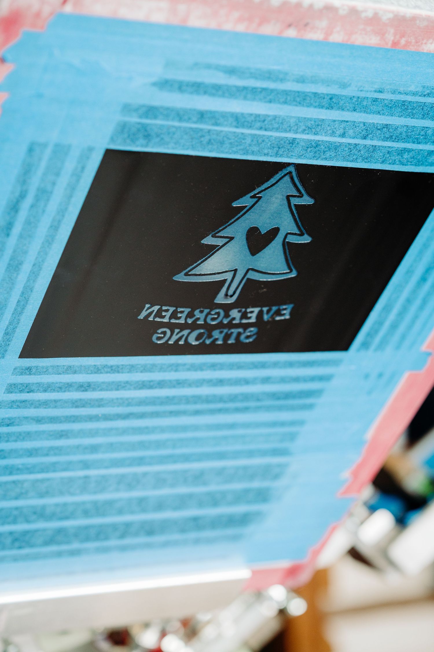 Close-up photo showing a series of business cards in blue tones with a tree-shaped logo design repeating across them.