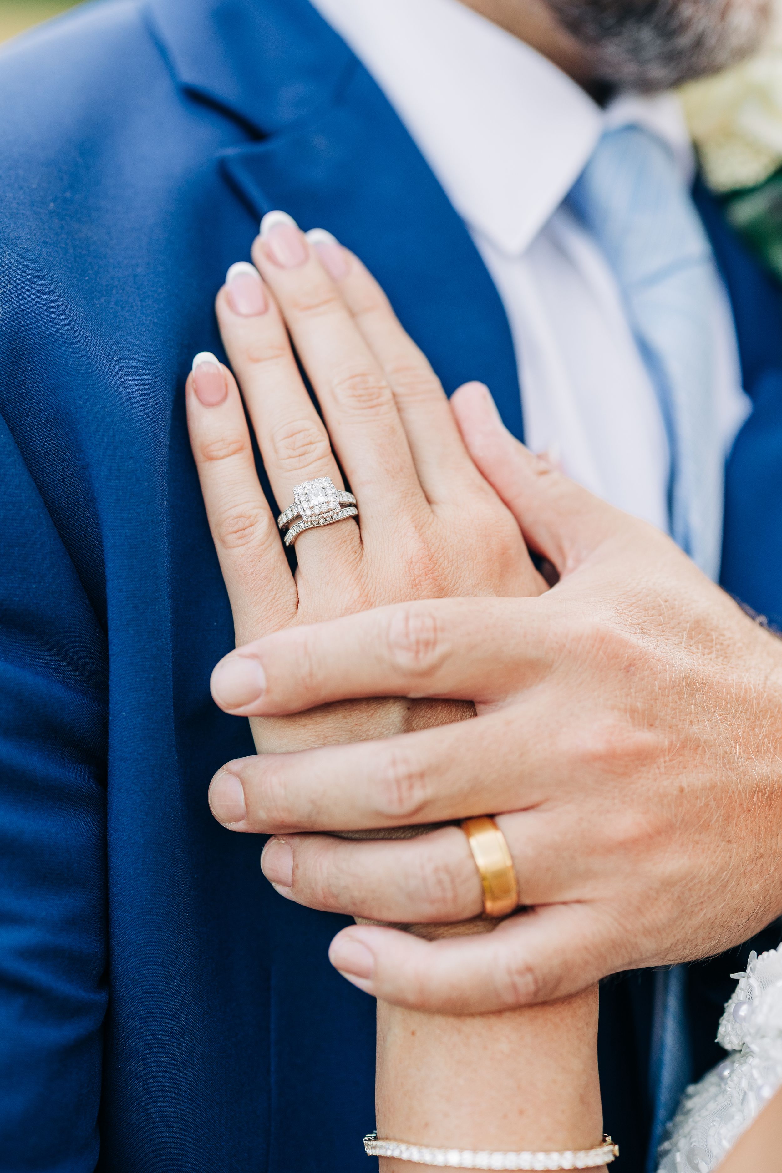 Close-up shots showing hands with wedding rings being displayed in sequence against blue suit.