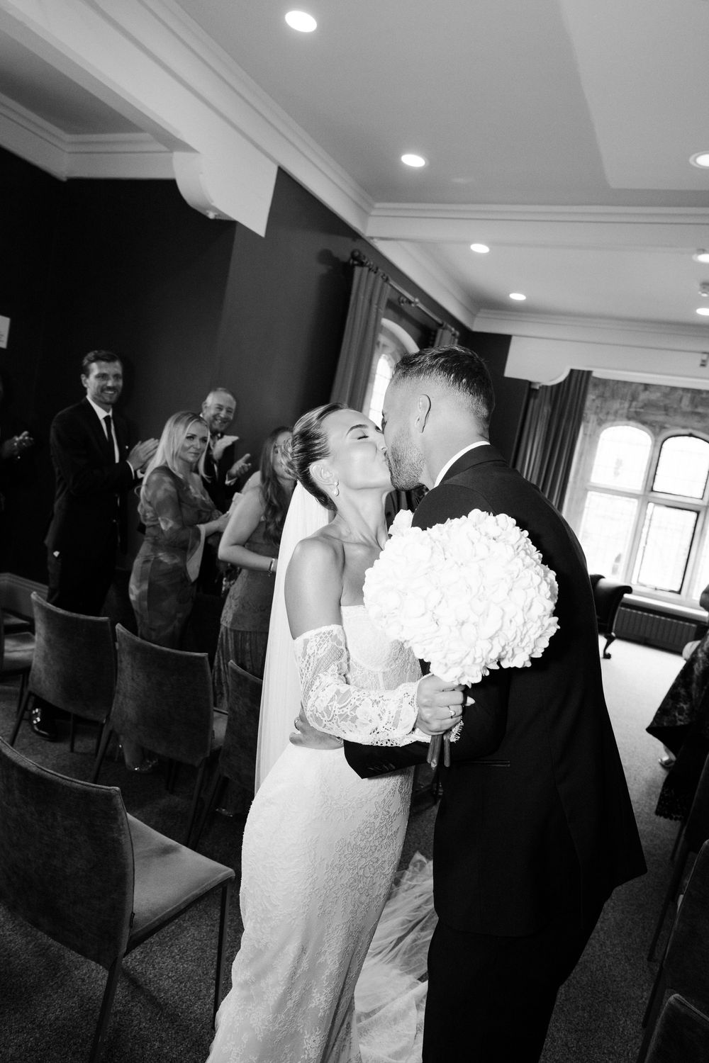 A sequence of black and white photos showing a romantic wedding moment with a couple holding white floral bouquets.