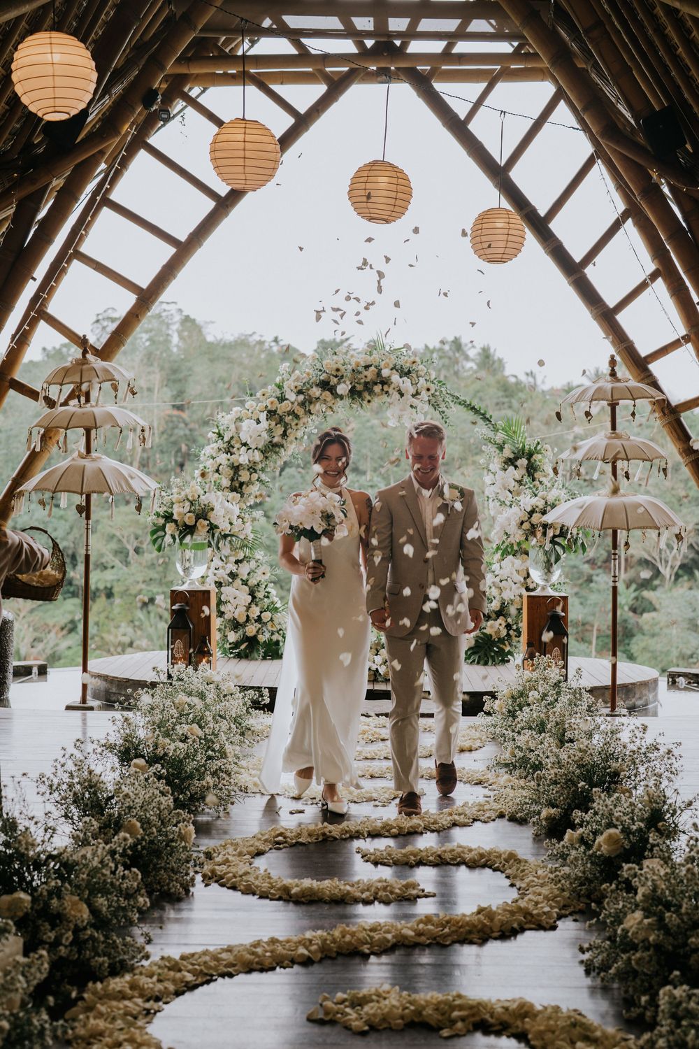 Rustic barn wedding venue decorated with paper lanterns and floral arrangements.
