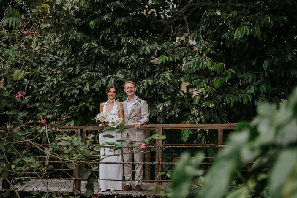 Wedding couple embraces in a lush garden setting during an outdoor celebration.