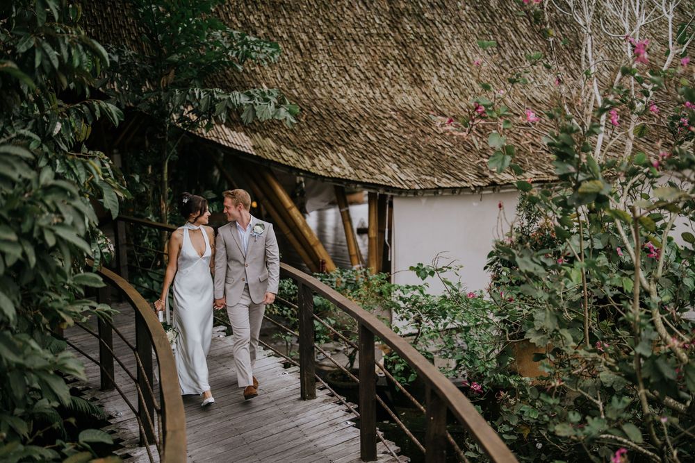 Rustic wooden pathway surrounded by tropical greenery and natural landscaping.