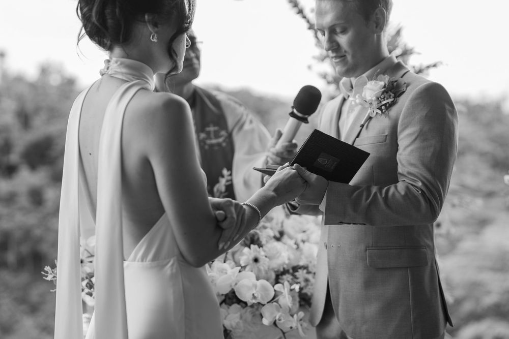 Black and white capture of intimate wedding ceremony exchange.