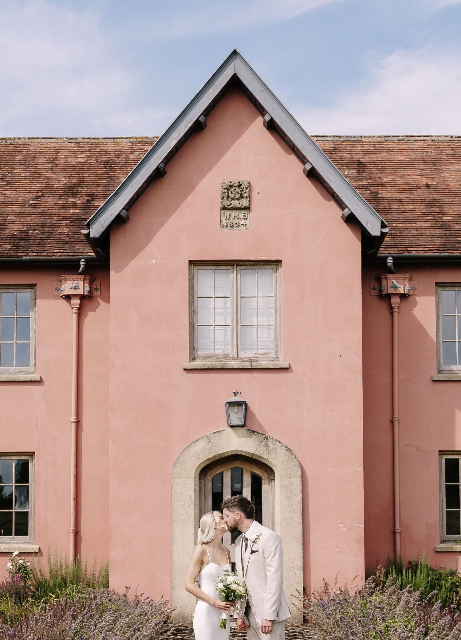 A sequence of photos showing a pink-colored rustic barn building during a countryside wedding celebration.