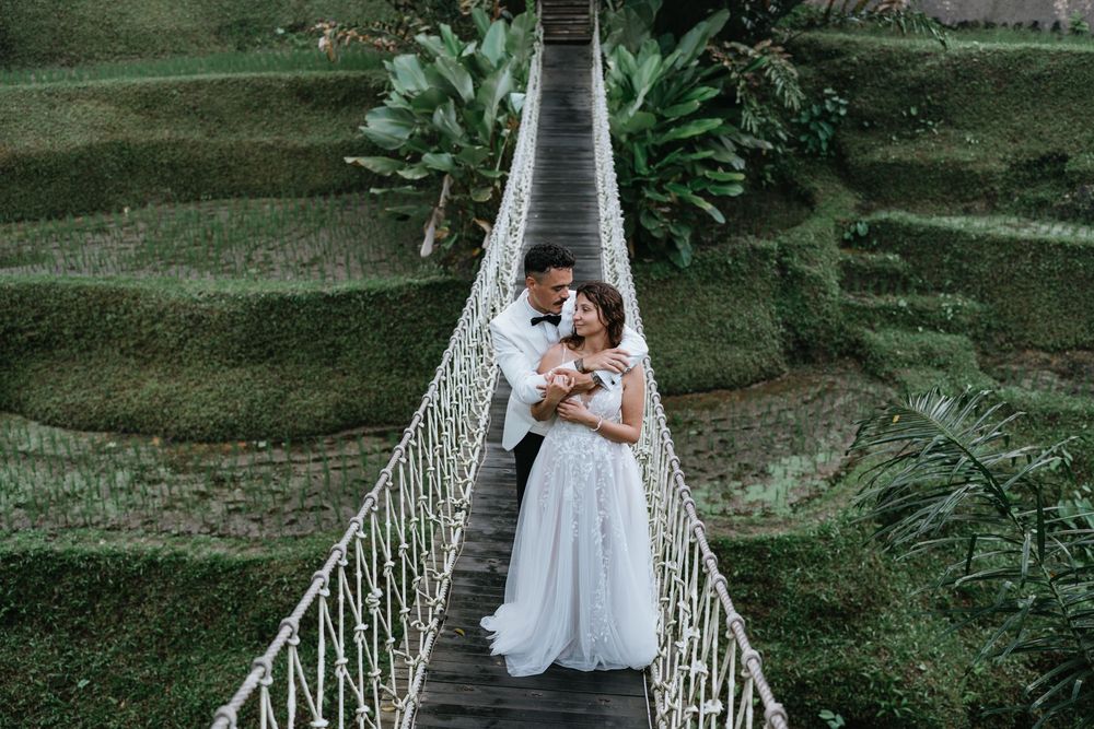 Romantic couple portrait on a suspension bridge surrounded by tropical greenery.