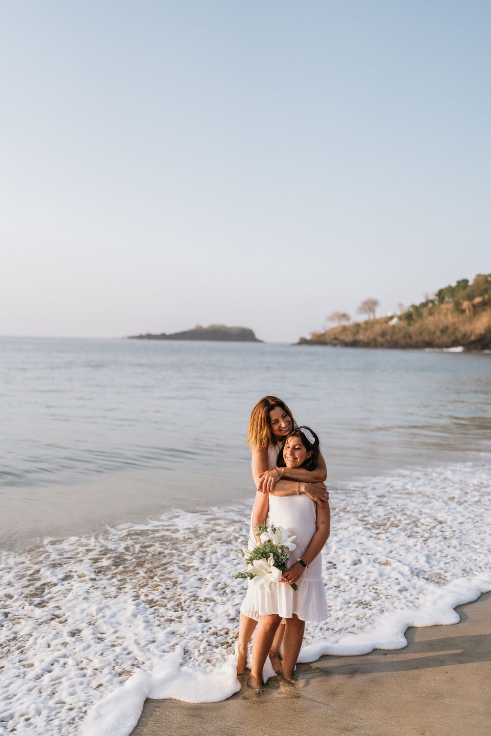 Couple sharing romantic moment by ocean waves on sandy beach.