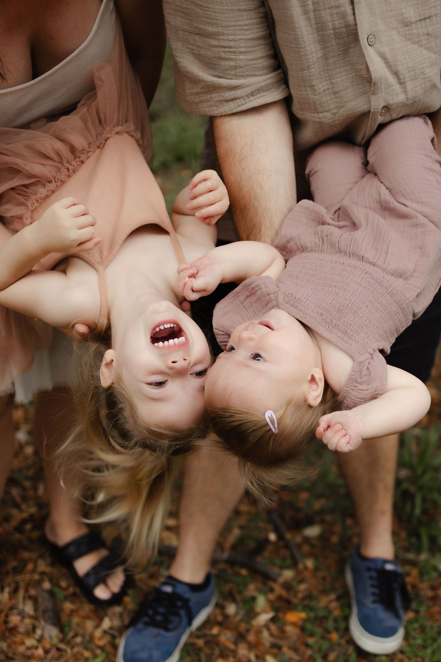 Family shares playful moments outdoors during a sunset photoshoot.
