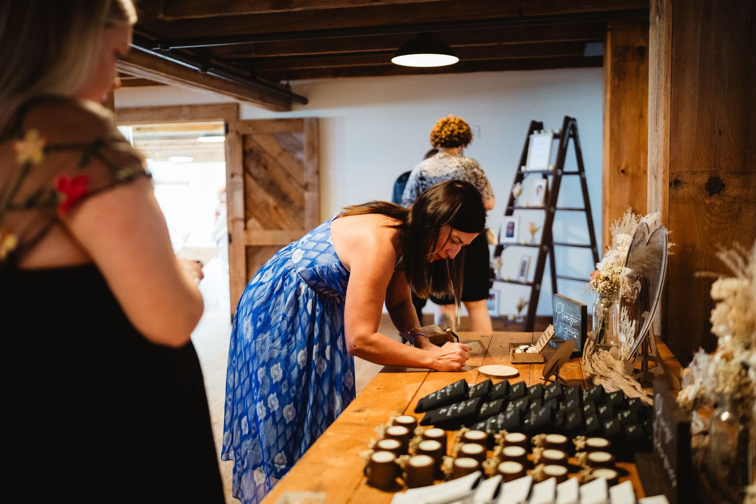 People preparing food and desserts at a rustic wooden counter with a ladder in the background.