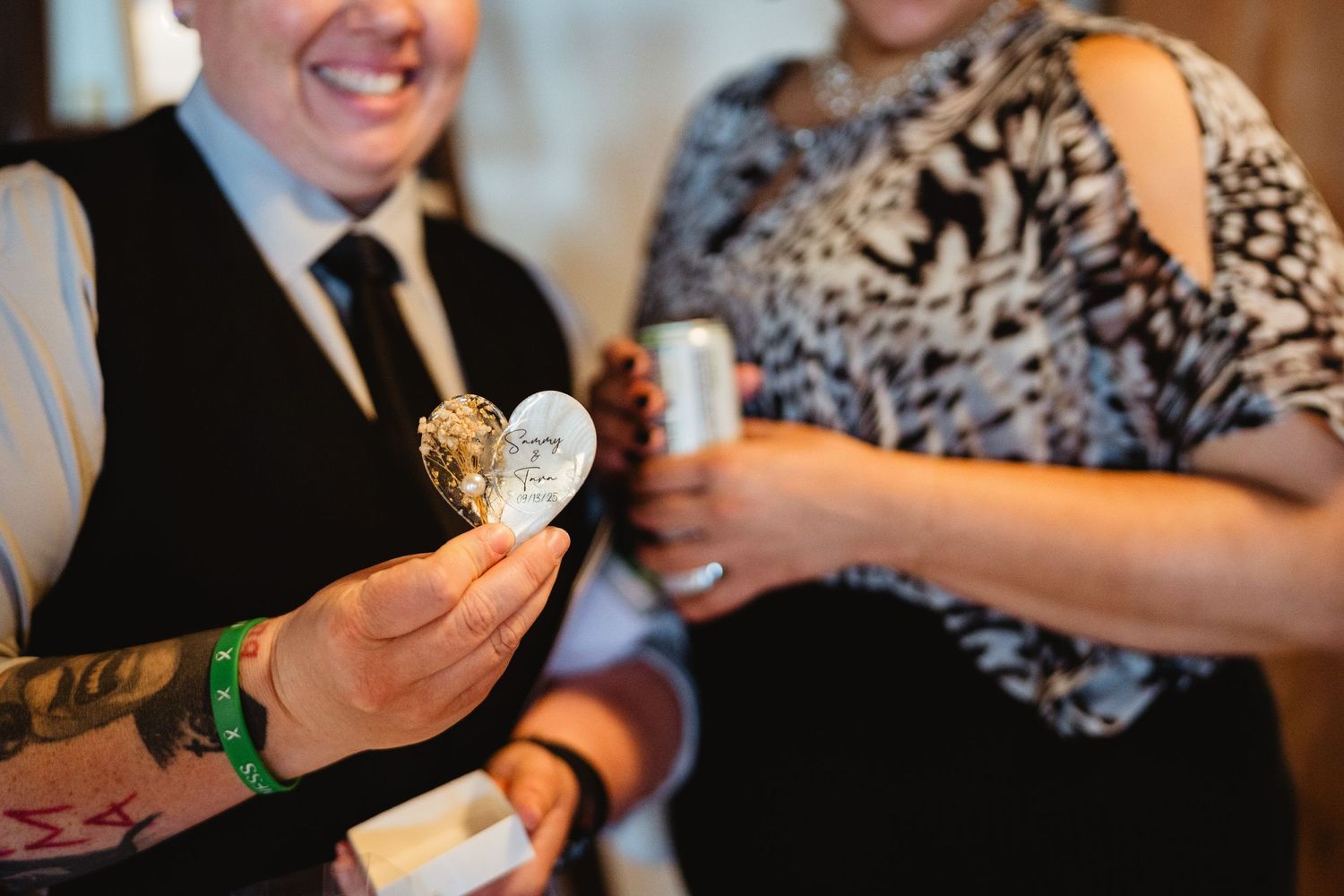 A group wearing formal attire sharing a conversation and laughing at a social gathering.