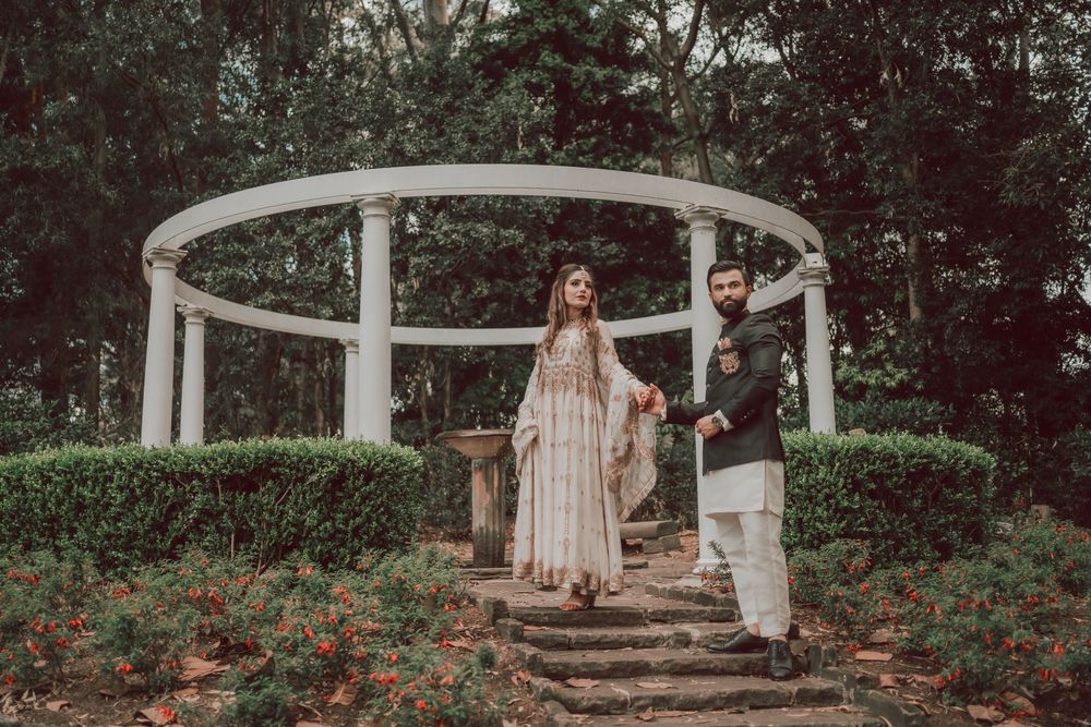 A romantic garden scene with a white gazebo and blooming red roses creates an enchanting wedding setting.