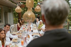 Elegant outdoor dinner party with hanging lanterns and table settings.
