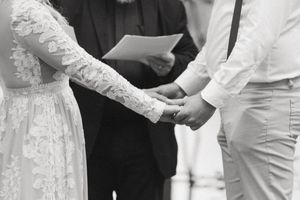 Close-up of hands during an outdoor wedding ceremony.