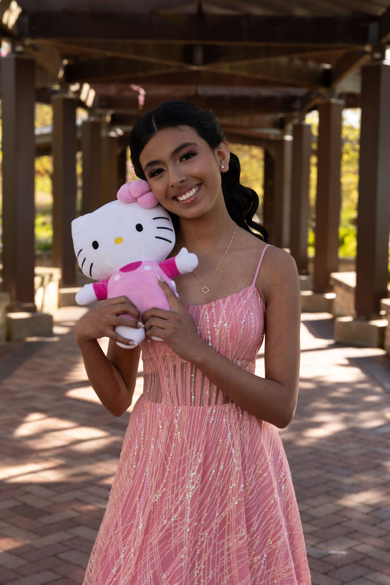Sweet 16 girl posing with a Hello Kitty plush in a scenic garden. Personalized Sweet 16 portrait session in Lake County by Alex T Photograph