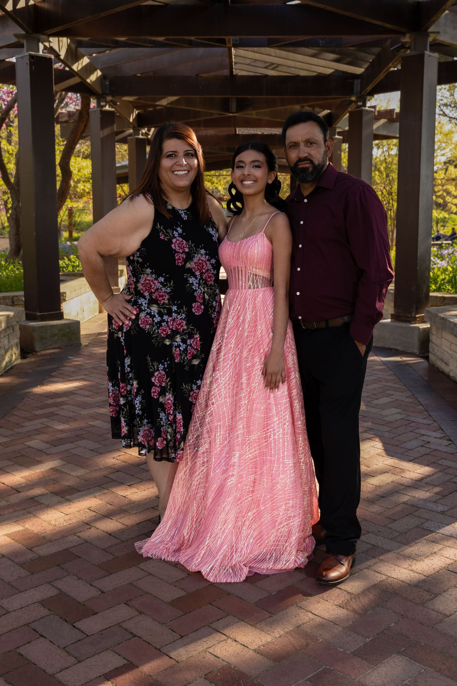 Full-length portrait of a Quinceañera in her yellow gown with family at Independence Grove. Professional XV park portraits by Alex T.