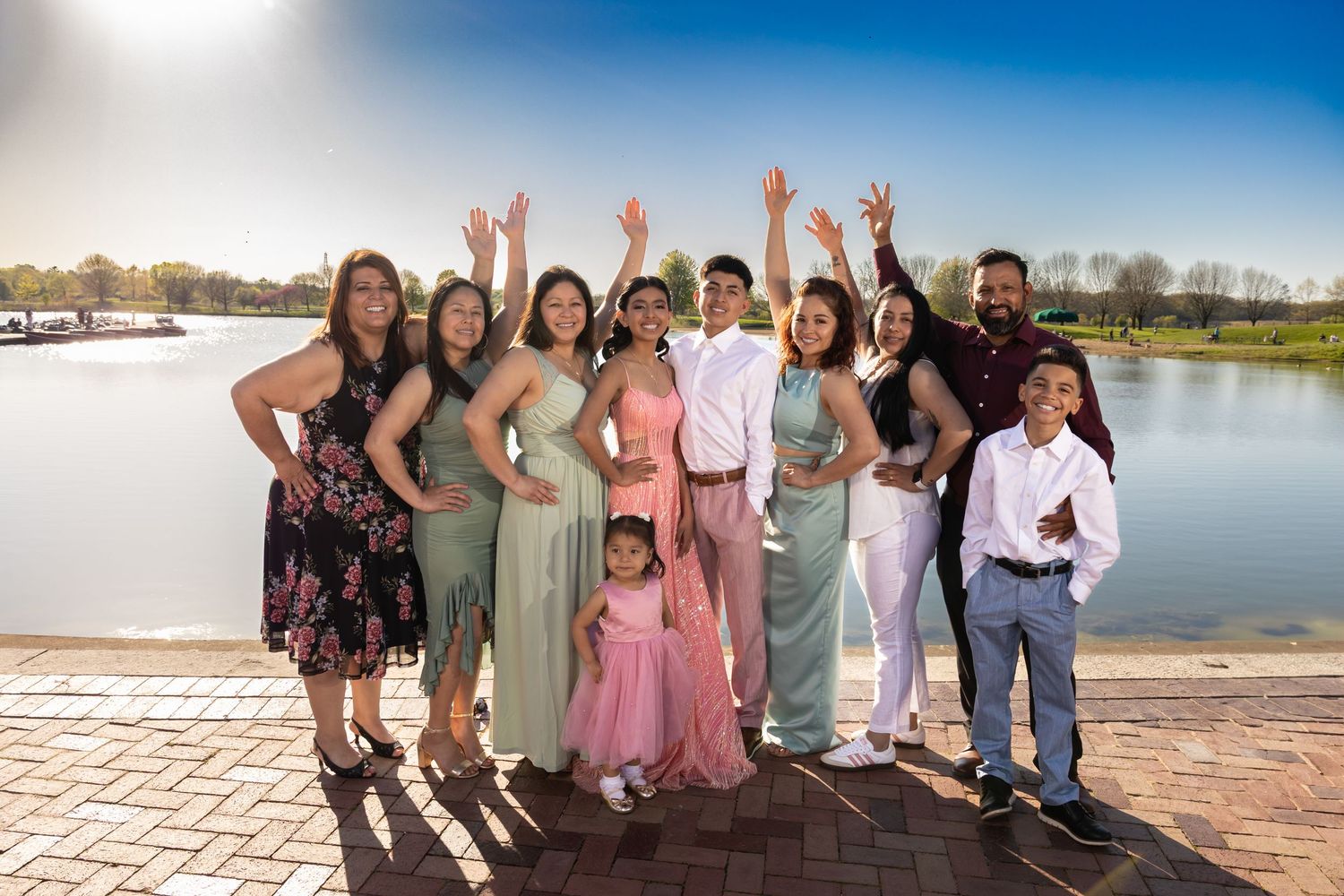 Group of friends and family cheering by the lake at sunset. Professional outdoor event and lifestyle photography by Alex T Photography.