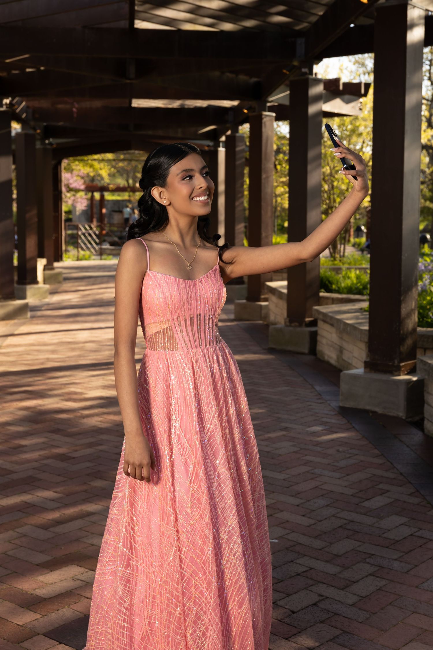 Full-length portrait of a girl in a pink formal gown under a garden pergola. Elegant Sweet 16 park portraits in Lake County by Alex T.