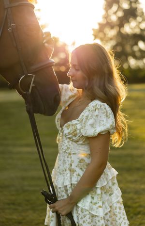A romantic golden hour portrait in a floral dress against sunset.
