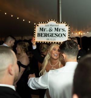 Wedding reception dance floor with illuminated Mr. & Mrs. sign.