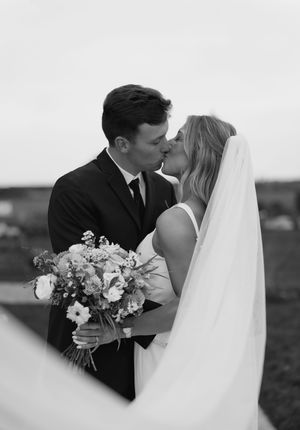 Romantic black and white portrait of newlyweds with bridal bouquet.