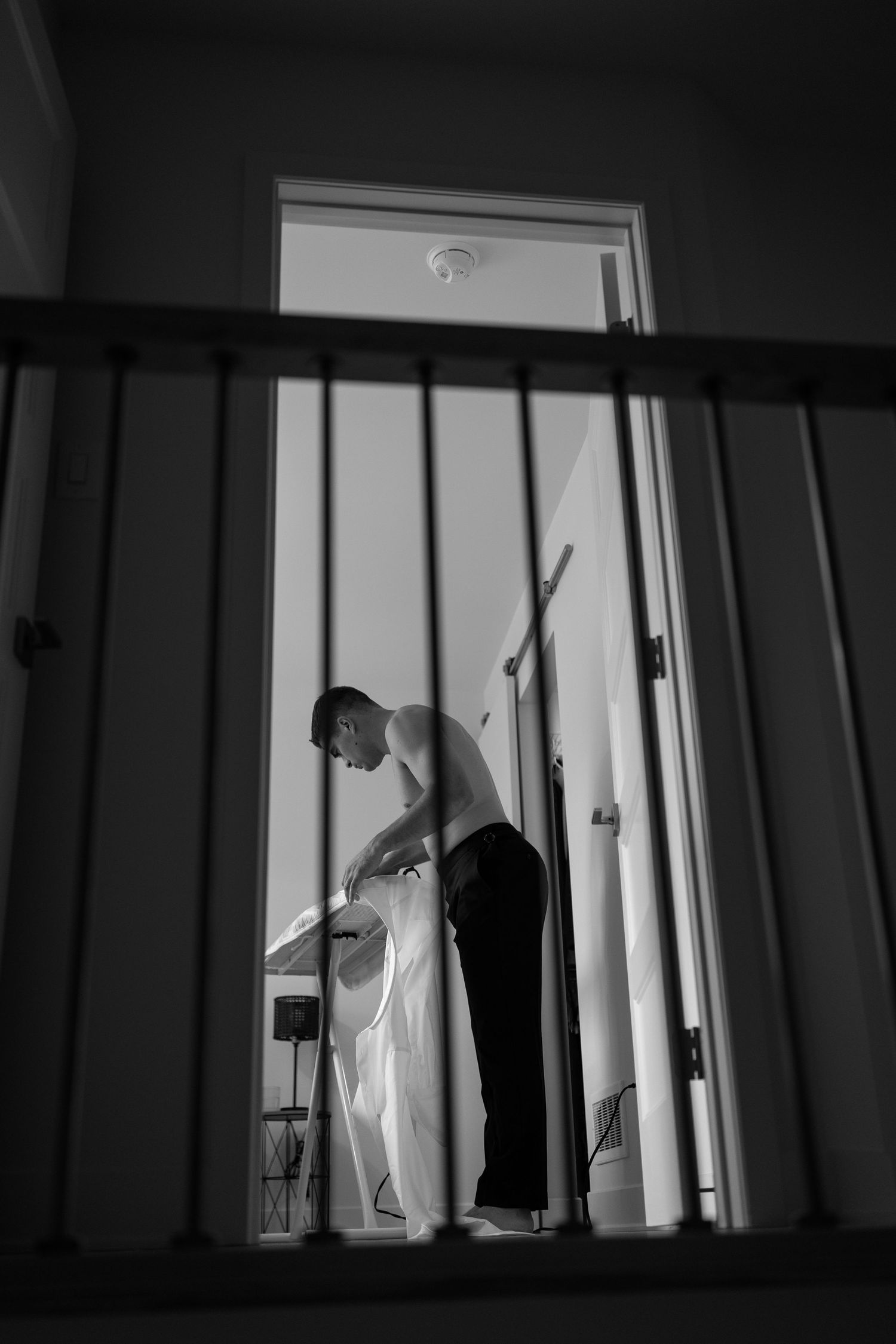 A dramatic black and white sequence showing a silhouetted figure moving behind window blinds in a dark room.