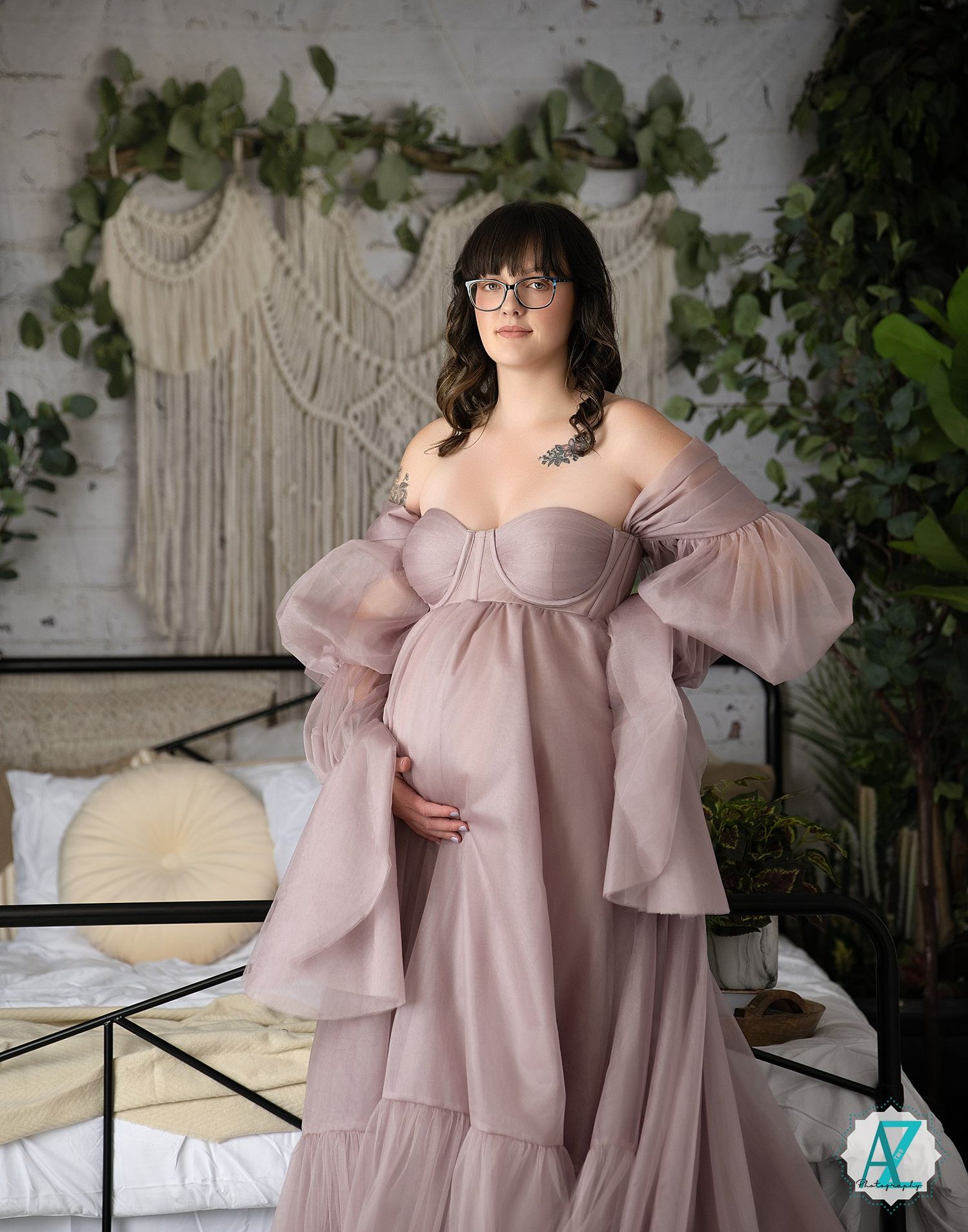 Studio photoshoot featuring flowing mauve dress against white backdrop with greenery.