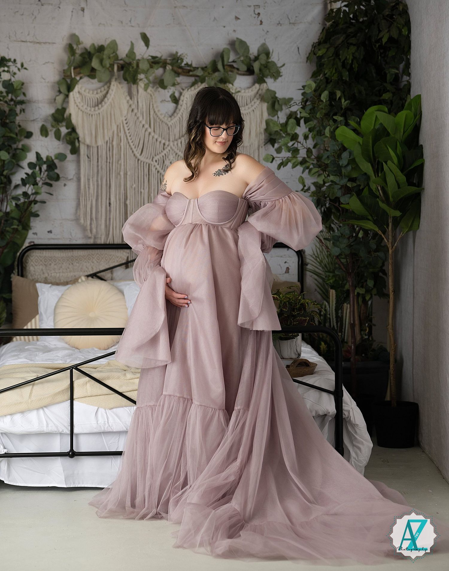 Full-length portrait in dusty rose gown with dramatic sleeves against white wall with climbing vines.
