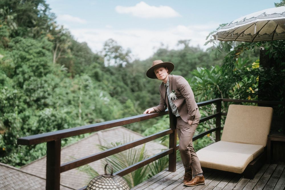 A wooden deck with lounge furniture overlooks a lush tropical landscape.