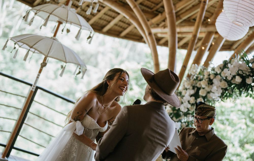 Wedding ceremony scene under a wooden pavilion with hanging paper lanterns and natural lighting.