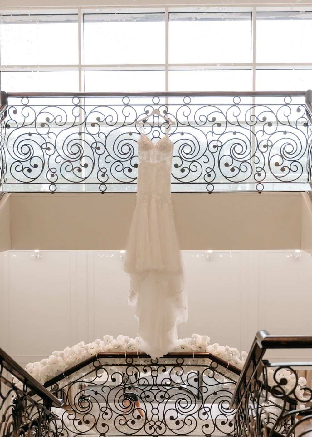 Decorative iron railing detail with swirling patterns against white wall.
