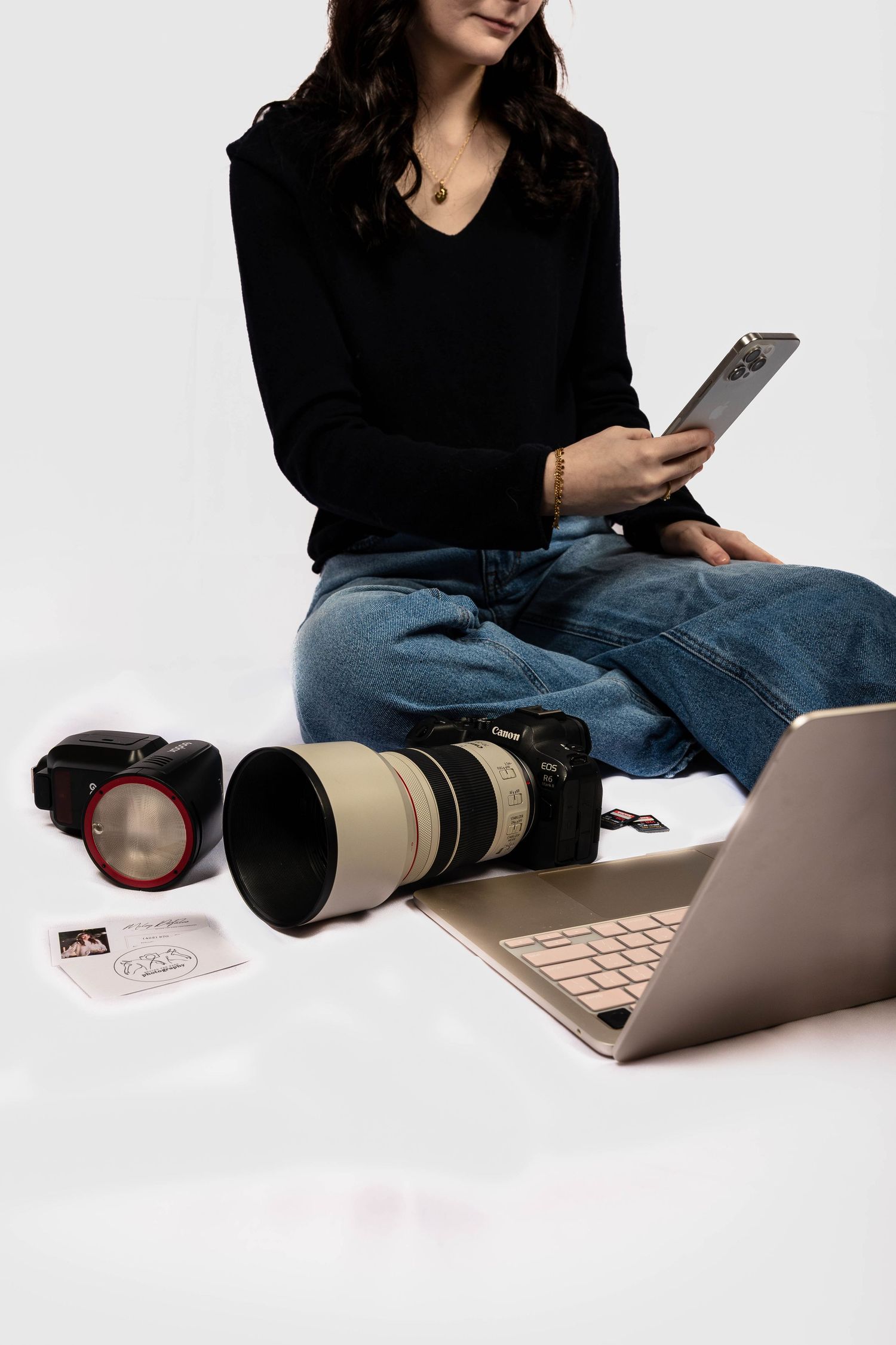 Side profile view of a photographer holding a camera against a dark background with dramatic lighting.