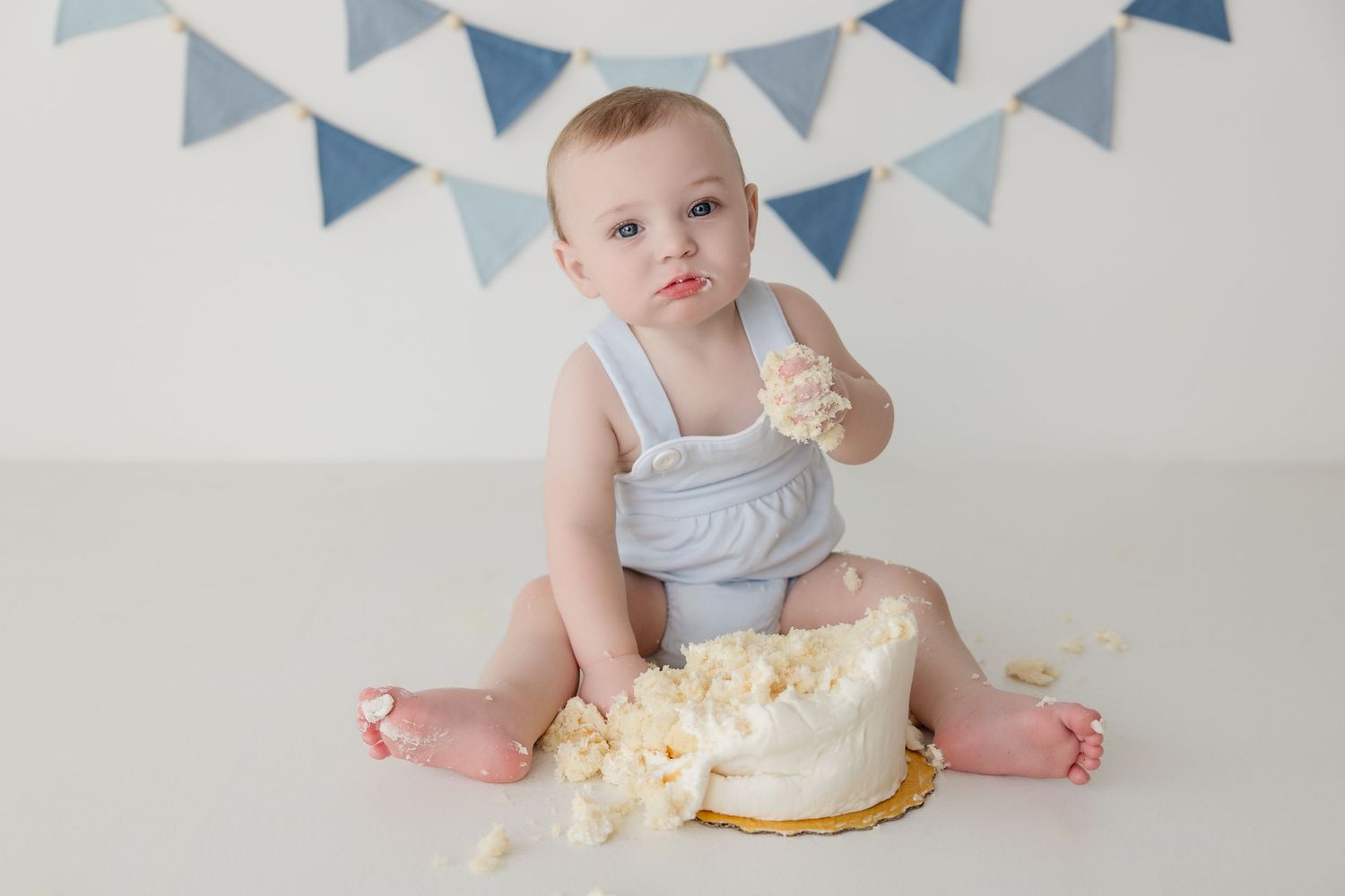 A series of milestone photos showing a baby with a cake smash and monthly celebration markers during their first year.