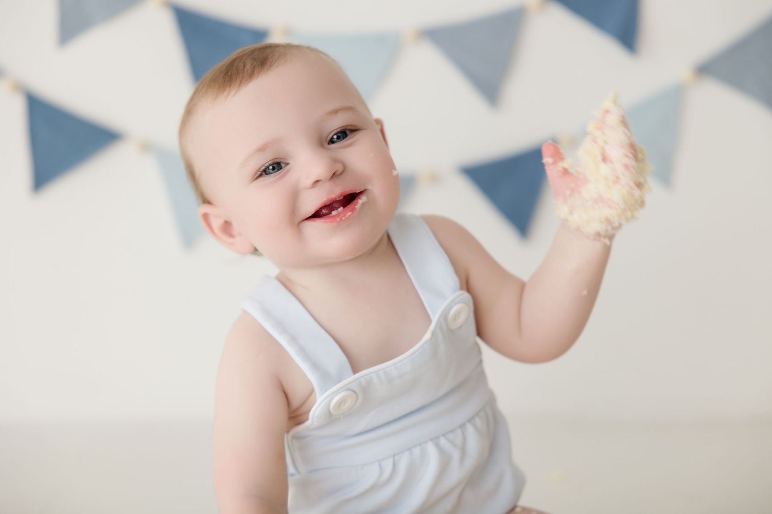 Sweet baby with white bunting against blue and gray triangle banner decorations.