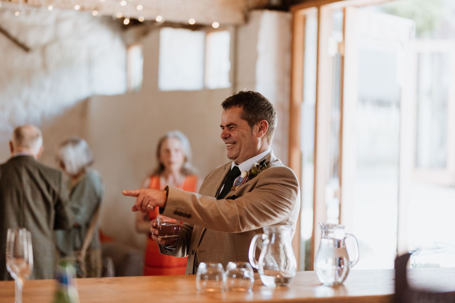 Wedding guest pointing and laughing during wedding reception