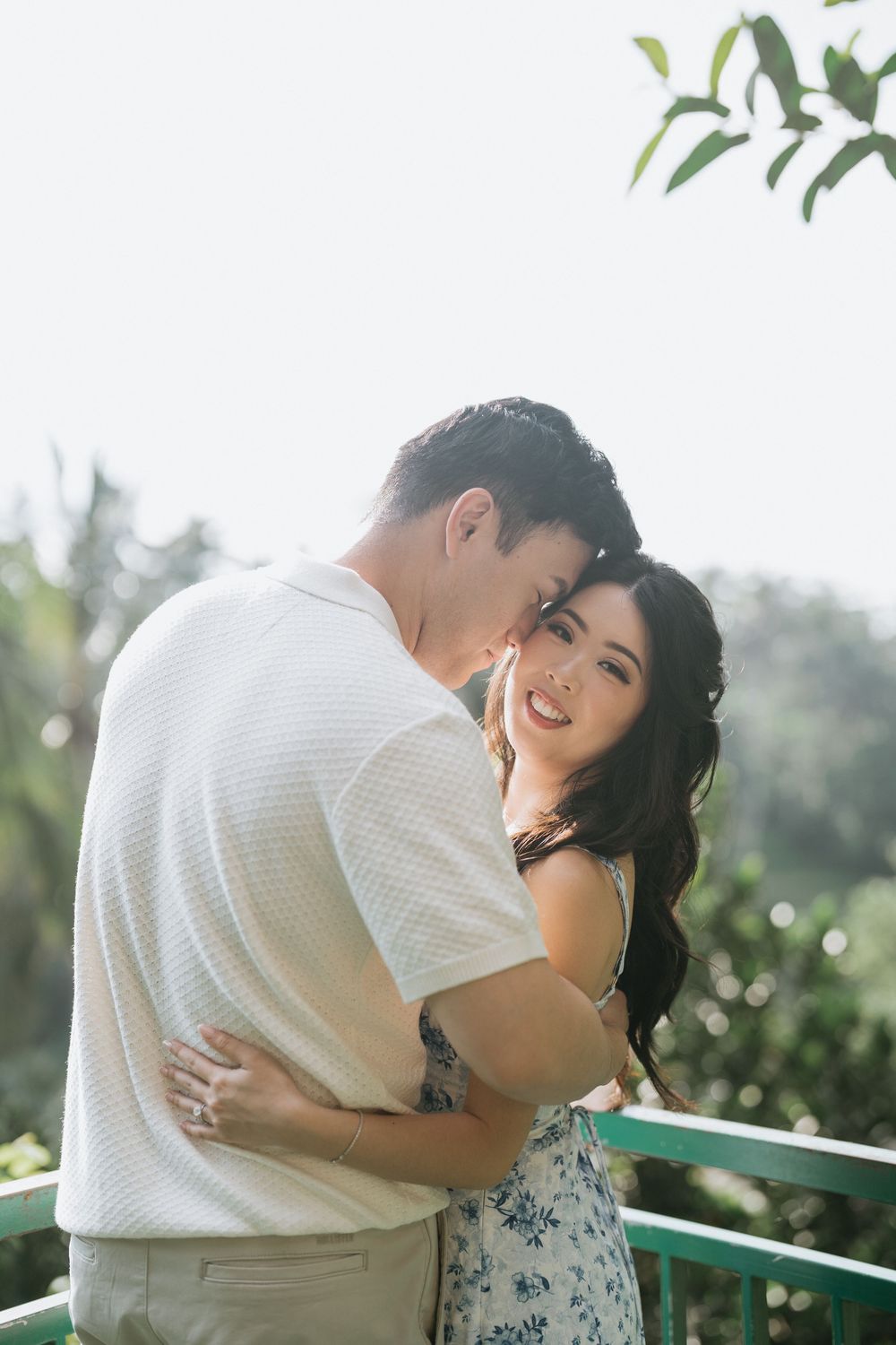 A sunlit embrace captured against a soft natural backdrop.