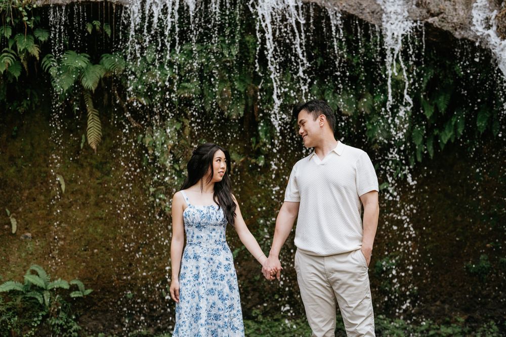 Misty waterfall creates a dramatic backdrop in a lush tropical forest setting.