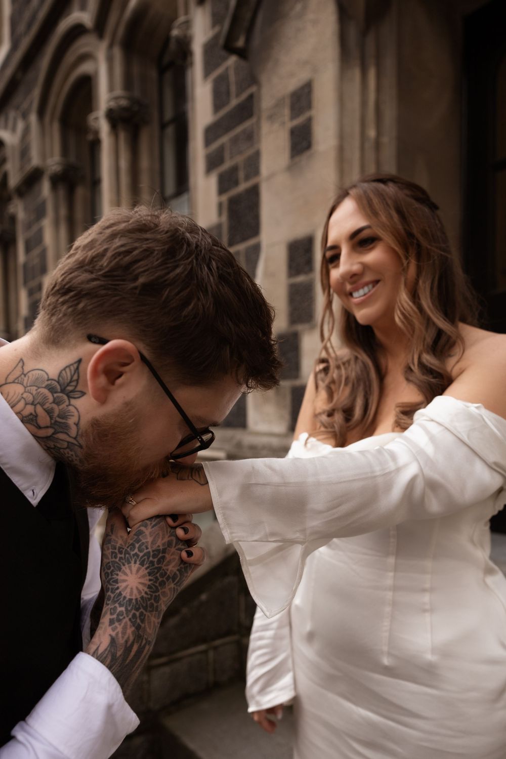 groom kissing wifes hand during photoshoot after elopement ceremony